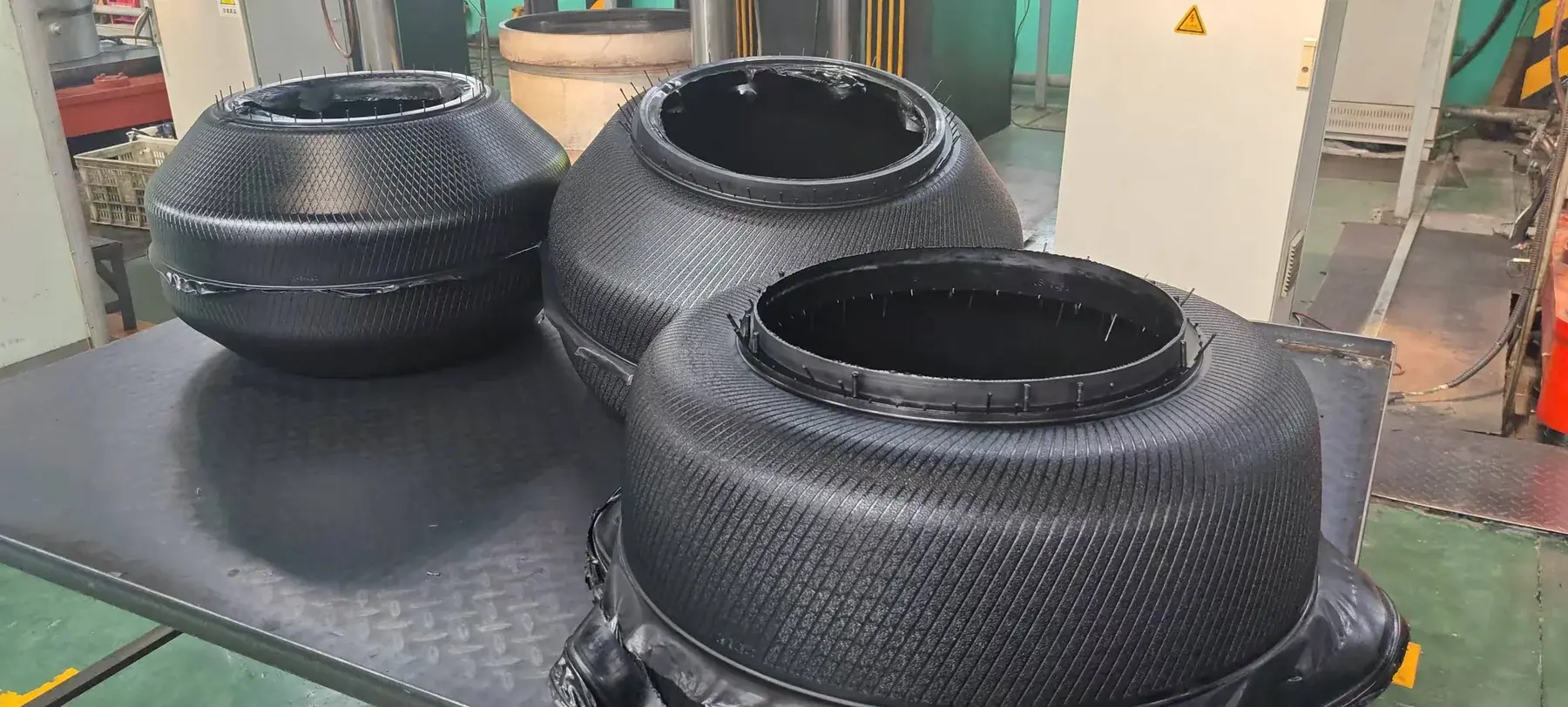 Authorized photograph of tire curing bladders on a worktable at Yongyi Rubber