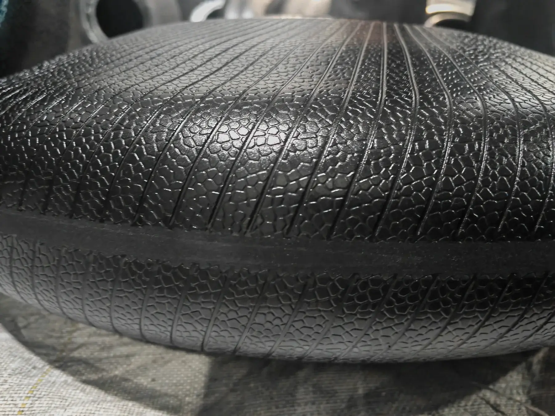 Close-up of intersecting etched grooves on a tire curing bladder surface